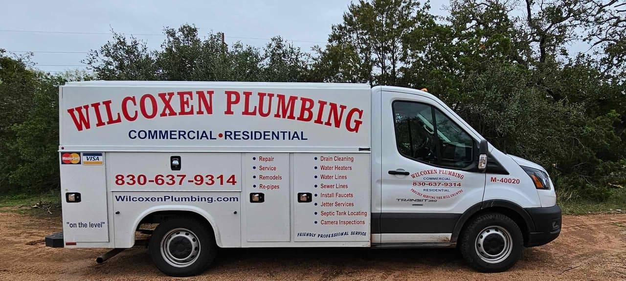 Wilcoxen Plumbing service truck, a white work van lettered with the company name, phone number and commercial and residential plumbing services